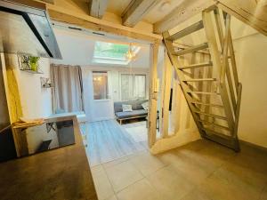 a living room with a wooden staircase in a house at Charmante maison triplexe avec jardinet in Orléans