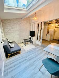 a living room with a couch and a tv at Charmante maison triplexe avec jardinet in Orléans +30 photos
