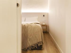 a small bedroom with a bed and a table at Decô Apartments Barcelona-Born Apt. in Barcelona