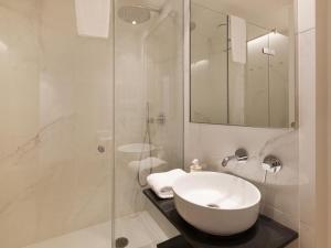 a white bathroom with a sink and a shower at Decô Apartments Barcelona-Born Apt. in Barcelona +16 photos