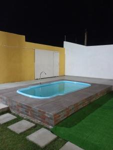 a swimming pool in the middle of a patio at night at Cantinho do sossego in Ilhéus