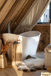 a bathroom with a white bath tub in a attic at Sichlańskie Spanie in Murzasichle