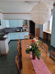 a kitchen with a wooden table with flowers on it at Tyforsgården in Mjölnartorpet