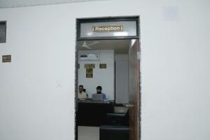 an entrance to an office with a sign that reads reception at Hotel Sky Blue in Surat