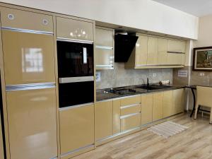 a kitchen with yellow cabinets and a stove top oven at Ardbay Apartment in Golem