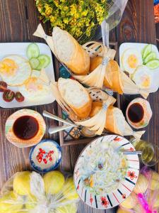 a table topped with plates and bowls of food at Homestay & Camping Phan Thiet Beach in Ấp Bình Hưng
