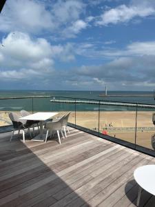 a balcony with a table and chairs and a beach at El Mirador - Quality Stay in Ostend