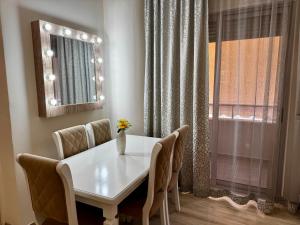 a white dining room table with chairs and a mirror at Ardbay Apartment in Golem