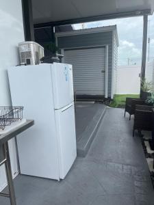 a white refrigerator on a patio with a garage at Courtside Villa at Key Largo in Key Largo