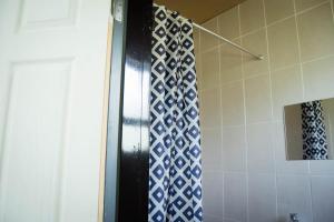 a bathroom with a shower with blue and white tiles at Bernliz Guest House in Bokong