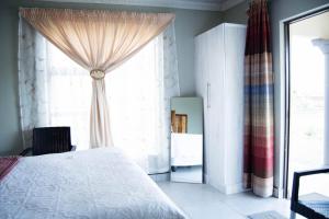a bedroom with a bed and a large window at Bernliz Guest House in Bokong