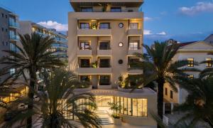 a large white building with palm trees in front of it at Cento Palme in Rhodes Town