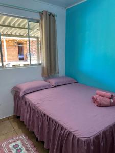 a bedroom with two beds with purple sheets and a window at Pousada Raio de Sol - SUPERAGUI - PR in Superagui +66 photos