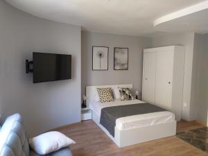 a bedroom with a bed and a flat screen tv at Студио Ирма in Burgas