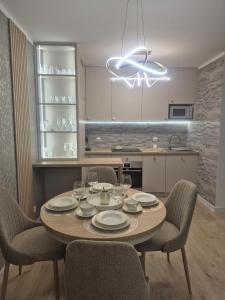 a kitchen with a table with chairs and a dining room at Major Apartment in Dziwnów