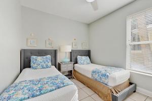 a bedroom with two beds and a window at Topsail Village #511 - Beach Moon in Santa Rosa Beach +18 photos