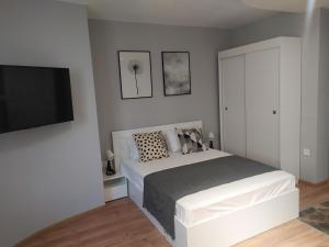 a bedroom with a bed and a flat screen tv at Студио Ирма in Burgas