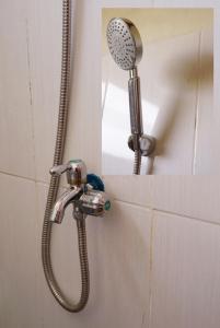 a shower with a shower head on a wall at Penginapan Homestay Mudiyono Syari'ah in Borobudur