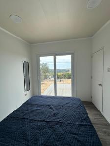 a bedroom with a bed and a large window at Tordos Lodge in Quintero +9 photos