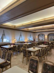 a dining room with tables and chairs and windows at Niederalteicher Hof in Hengersberg