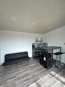 a living room with a black couch and a desk at Tordos Lodge in Quintero