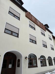 a white building with a door and windows at Niederalteicher Hof in Hengersberg