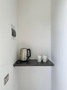 a counter with a coffee maker and two cups on it at Tordos Lodge in Quintero