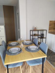 a wooden table with chairs and plates and wine glasses at Студио Ирма in Burgas +3 photos