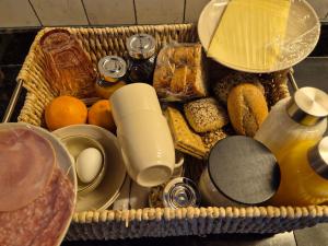 ein Korb gefüllt mit verschiedenen Brotsorten und Speisen in der Unterkunft Villa Bergstein in Tuk + 2 Fotos