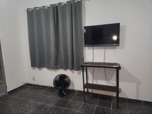 a room with a flat screen tv on a wall at Xaveco hospedagem in Mangaratiba