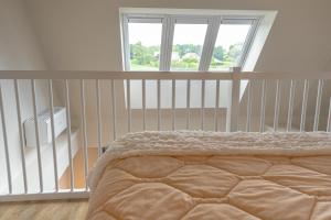 a bedroom with a bed and a window and a crib at B&B de Gouden Ploeg met Jacuzzi in Bergentheim