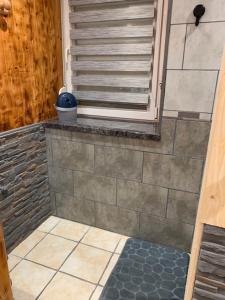 a bathroom with a shower with a tile floor at ferme des grands blaise in La Bresse