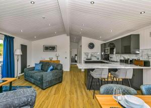 a living room with a couch and a kitchen at Finest Retreats - Silverwood Junior Chalet in Errol