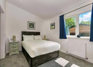 a bedroom with a large bed and a window at Finest Retreats - Silverwood Junior Chalet in Errol