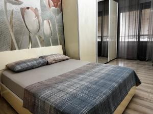 a bedroom with a bed and a wall with flowers at Ardbay Apartment in Golem +12 photos