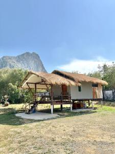 a hut with a thatched roof and a table and chairs at ริมบึงโฮมสเตย์ in Ban Phu Noi