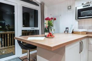 a kitchen with a wooden counter with a vase of flowers at Finest Retreats - Silverwood Spa Lodge in Errol