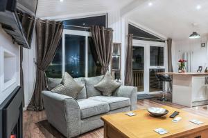 a living room with a couch and a table at Finest Retreats - Silverwood Spa Lodge in Errol