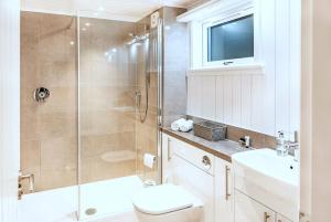 a bathroom with a shower and a toilet and a sink at Finest Retreats - Silverwood Spa Lodge in Errol +5 photos