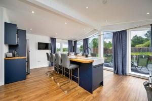 a kitchen with a island with chairs and a counter top at Finest Retreats - Silverwood Executive Chalet in Errol