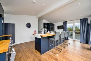 a kitchen with a island with bar stools at Finest Retreats - Silverwood Executive Chalet in Errol