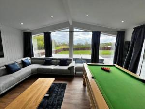 a living room with a pool table at Finest Retreats - Silverwood Executive Chalet in Errol