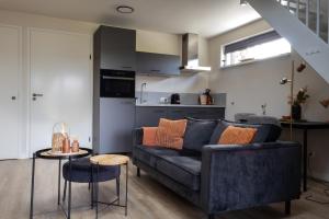 a living room with a couch and a kitchen at B&B de Gouden Ploeg met Jacuzzi in Bergentheim +10 photos