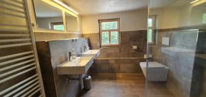 a bathroom with two sinks and a toilet at Gohrischer Hof Anno 1798 in Kurort Gohrisch