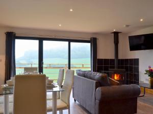 a living room with a couch and a table and a fireplace at Offa's Dyke Lodge - Uk10835 in Old Radnor