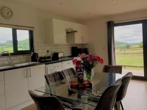 a kitchen with a glass table with a vase of flowers on it at Offa's Dyke Lodge - Uk10835 in Old Radnor +13 photos