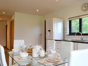 a kitchen with a glass table and white appliances at Offa's Dyke Lodge - Uk10835 in Old Radnor