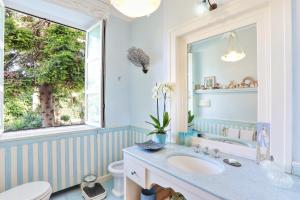 a bathroom with a sink and a toilet and a window at Villa Lalen Sorrento Private Luxury Residence with Garden, Terrace & Jacuzzi in Sorrento