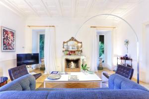 a living room with a blue couch and a fireplace at Villa Lalen Sorrento Private Luxury Residence with Garden, Terrace & Jacuzzi in Sorrento +41 photos