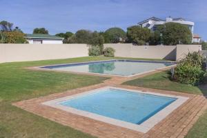 a swimming pool in the yard of a house at Log Cabin- Forest, Lagoon Sea location in Hermanus